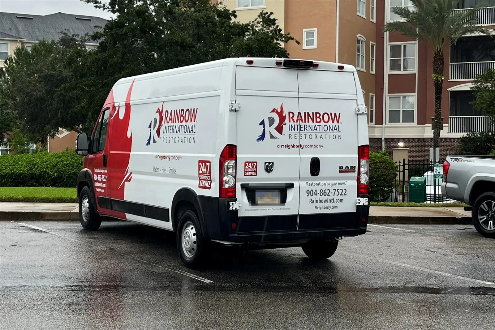 Rear of a Rainbow service van in a parking lot in the rain