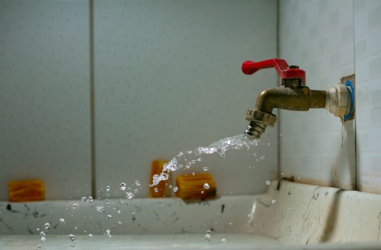 Burst water pipe with water spraying inside a home wall